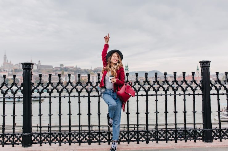 graceful-brunette-woman-standing-one-leg-city-holding-cup-tea_197531-6456