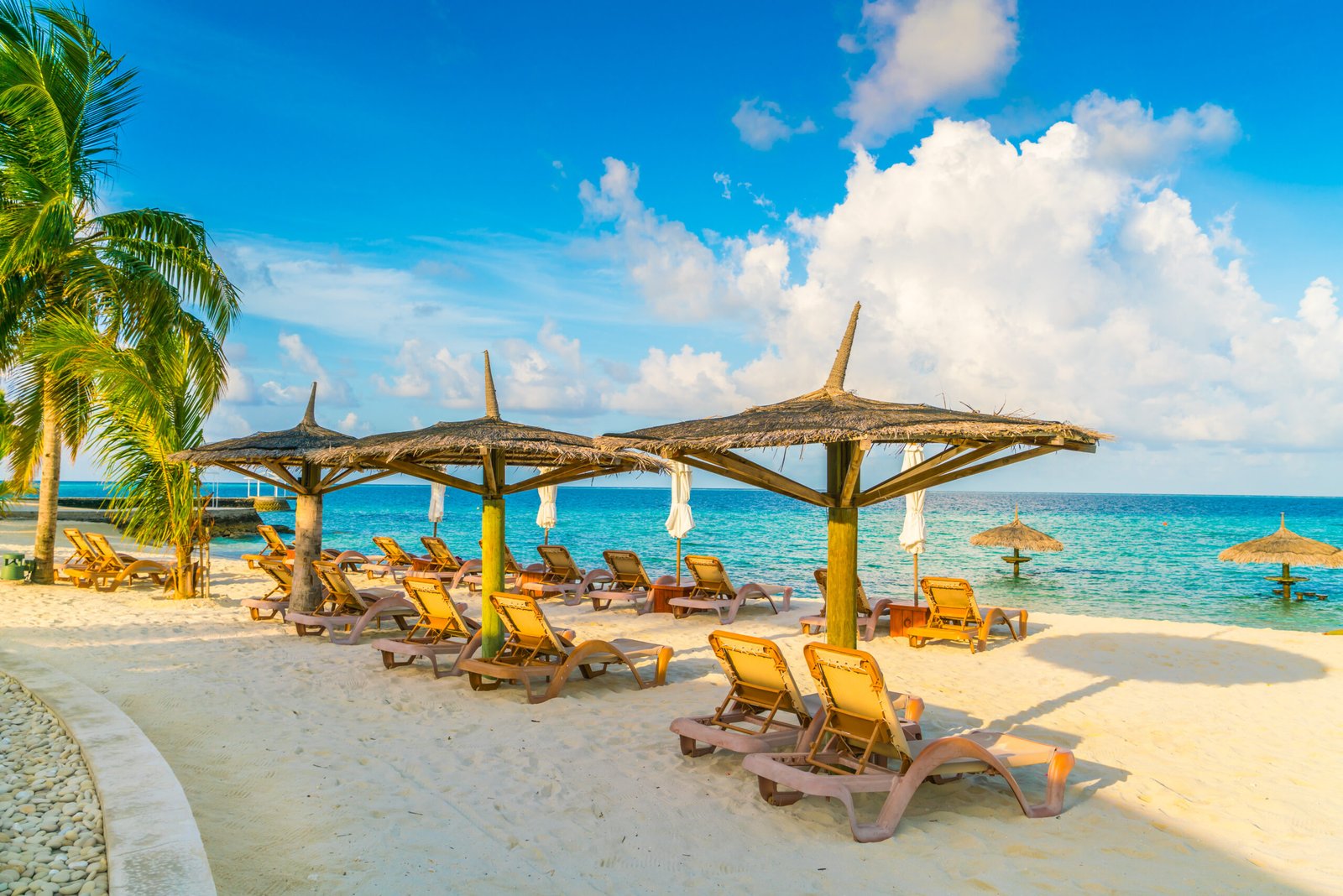 Beach chairs with umbrella at Maldives island, white sandy beach and sea